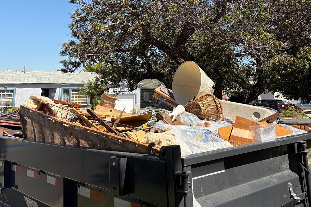 large dumpster filled with residential demolition debris and materials